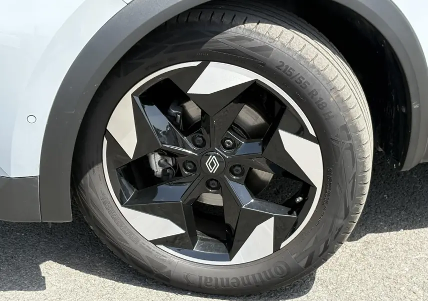 Gros plan sur la roue avant gauche du Renault Captur 2025, jante aluminium 18 pouces bicolore noir et gris.