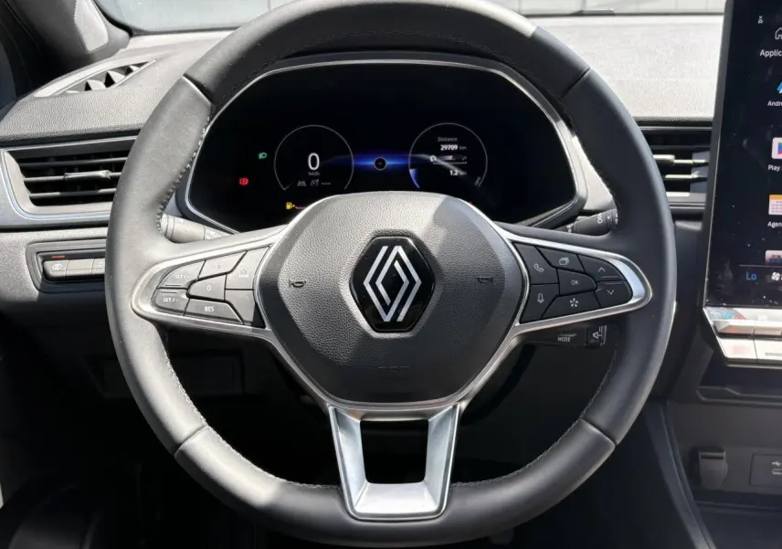 Vue centrée sur le volant noir du Renault Captur 2025 avec tableau de bord numérique et commandes intégrées.