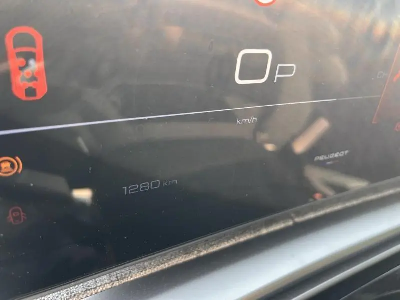 Détail du tableau de bord numérique du Peugeot 5008 Hybrid blanc, affichant 1280 km et indicateurs de sécurité.