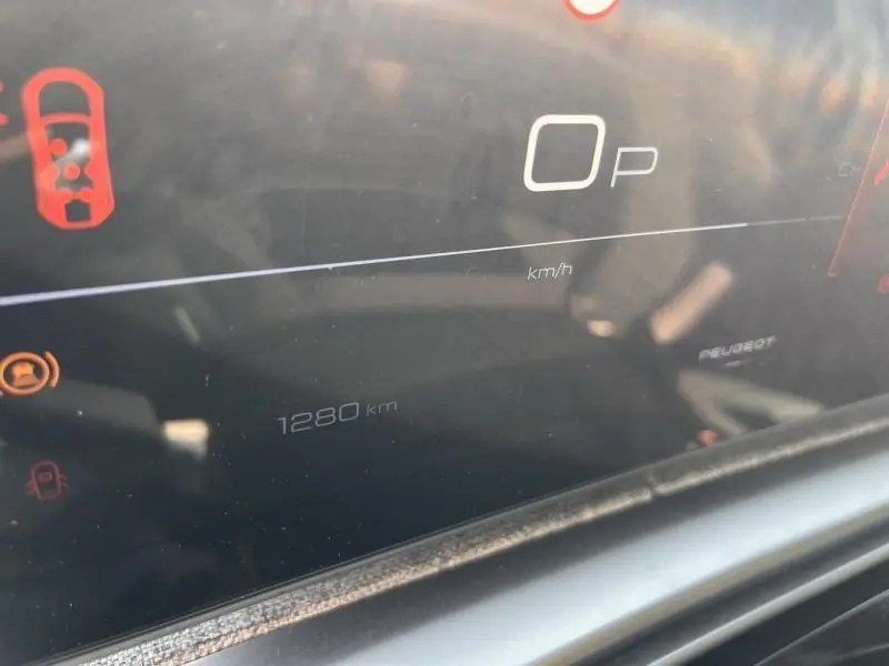 Gros plan sur le tableau de bord numérique du Peugeot 5008 Hybrid blanc, affichant 1280 km au compteur.