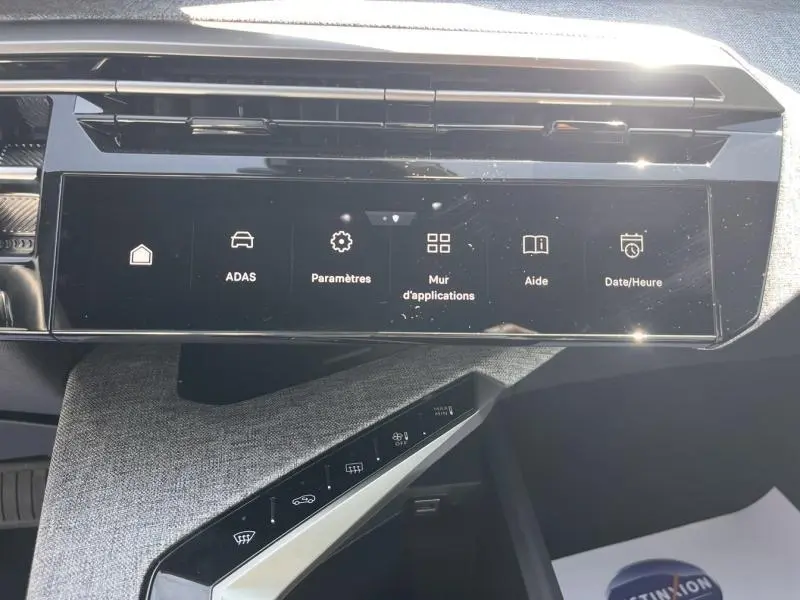 Vue rapprochée de l’écran tactile central et des commandes tactiles du tableau de bord du Peugeot 5008 blanc Okénite.