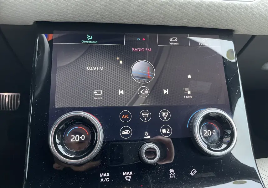 Gros plan sur l'écran tactile central et les commandes de climatisation du Range Rover Velar D300 2018 en intérieur noir et beige.