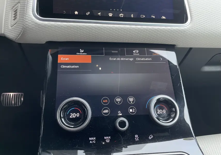Gros plan sur la console centrale tactile du Range Rover Velar 2018, avec réglages climatisation à 20°C.