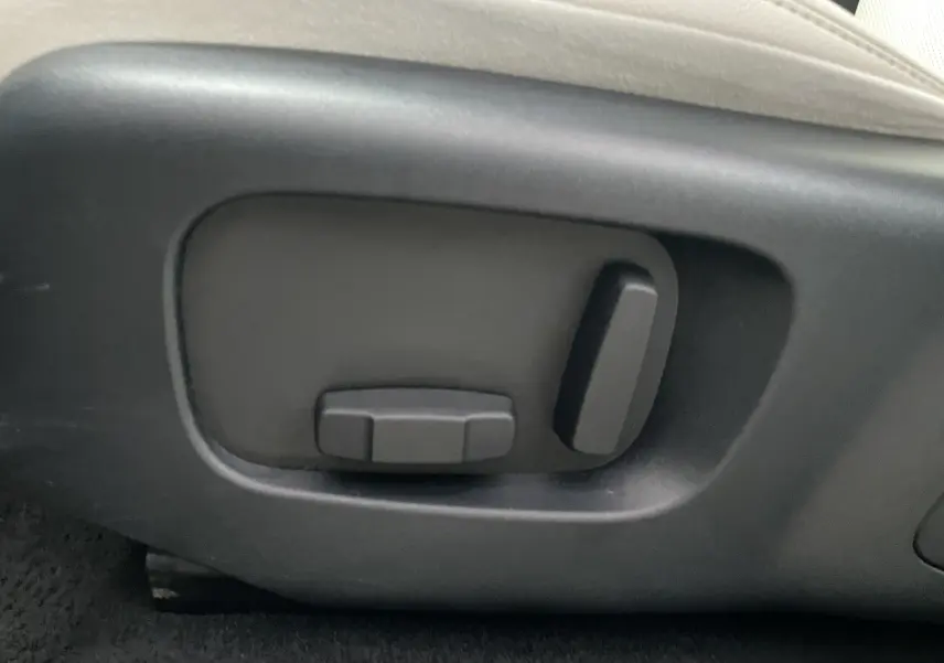 Gros plan sur les commandes électriques de réglage du siège côté gauche d'un Range Rover Velar gris Silicon Silver.