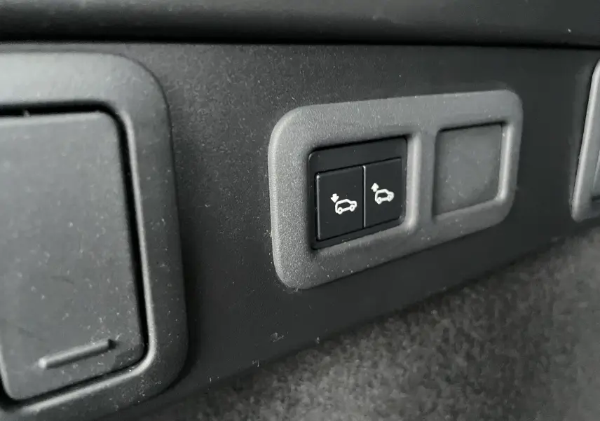 Boutons de commande de l'ouverture et fermeture électrique du hayon dans l'habitacle du Range Rover Velar gris Silicon Silver.