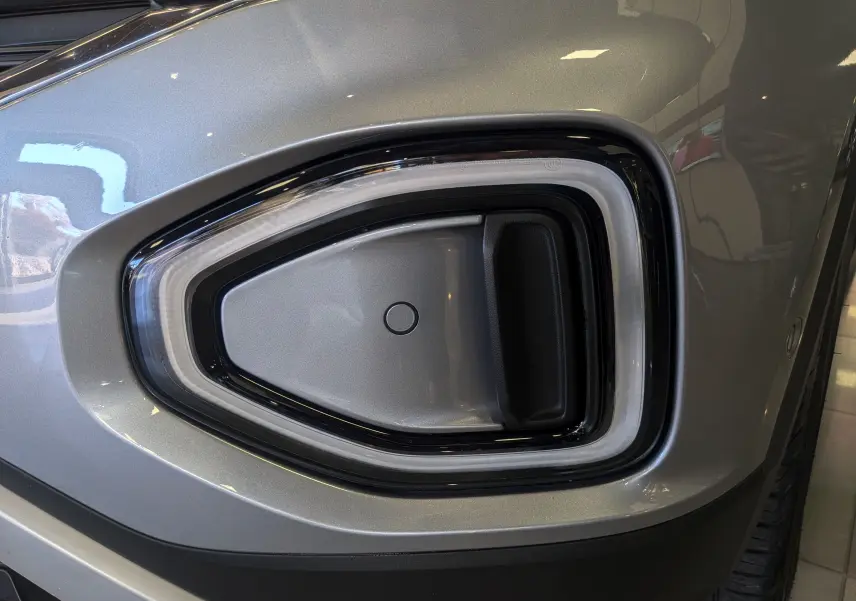 Gros plan sur le feu antibrouillard avant droit du Volkswagen T-Roc gris pyrite 2024, soulignant son design moderne.