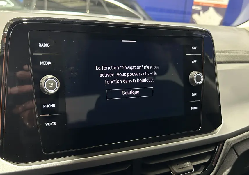 Écran tactile central du Volkswagen T-Roc 2025 affichant un message d'activation de la navigation, intérieur noir.
