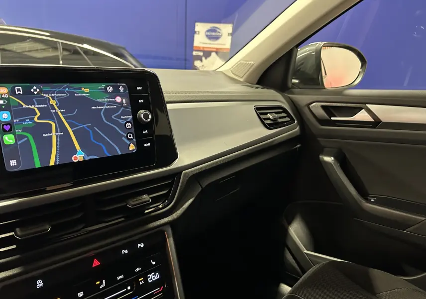Vue intérieure côté passager du tableau de bord et écran tactile affichant la navigation du Volkswagen T-Roc 2025.