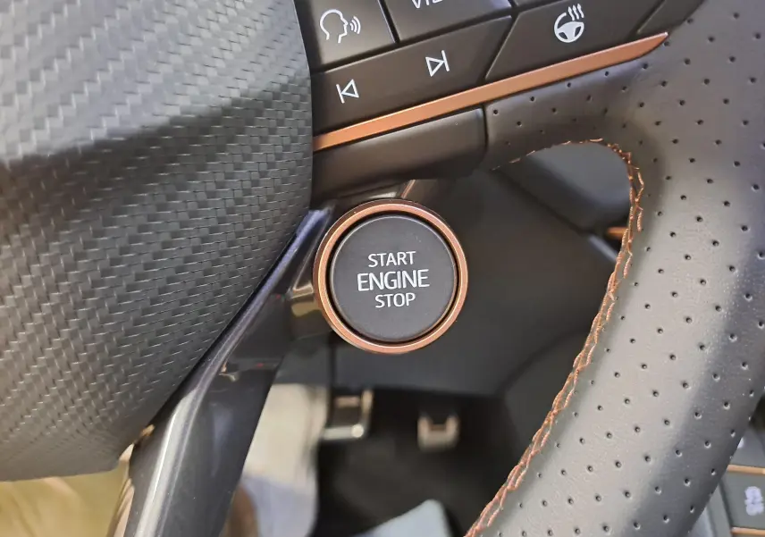 Gros plan sur le bouton Start Engine Stop entouré de cuir perforé avec surpiqûres cuivrées dans un CUPRA TERRAMAR.