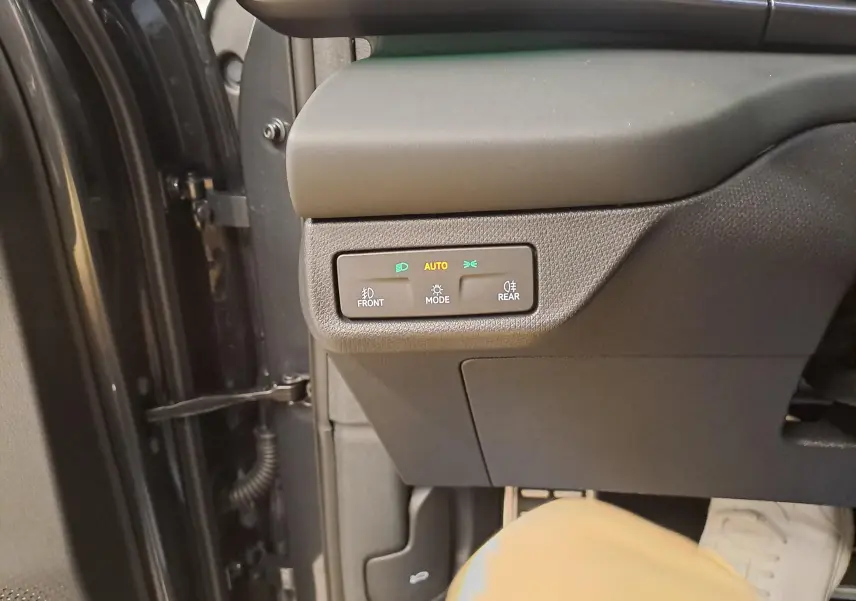 Gros plan sur les commandes d’éclairage côté gauche du tableau de bord d’un CUPRA TERRAMAR 2025 gris Timanfaya.