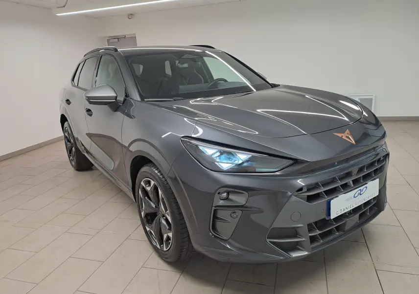 Vue 3/4 avant droite d'une CUPRA TERRAMAR 2025 gris Timanfaya avec jantes 19'' Cosmic usinées et feux allumés.