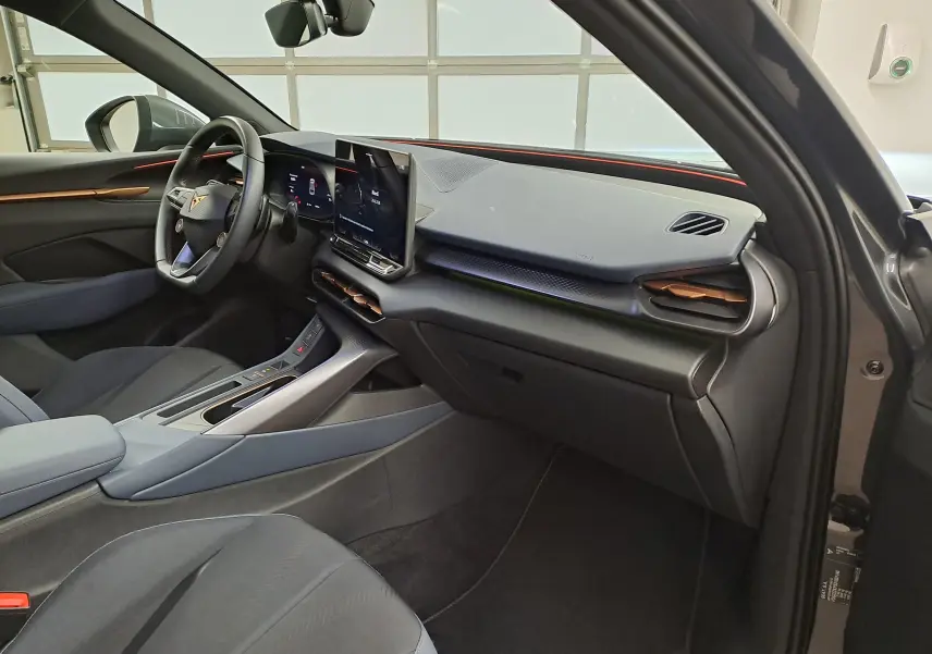 Vue intérieure côté conducteur de la CUPRA TERRAMAR 2025 avec tableau de bord noir et inserts cuivrés, écran central tactile visible.