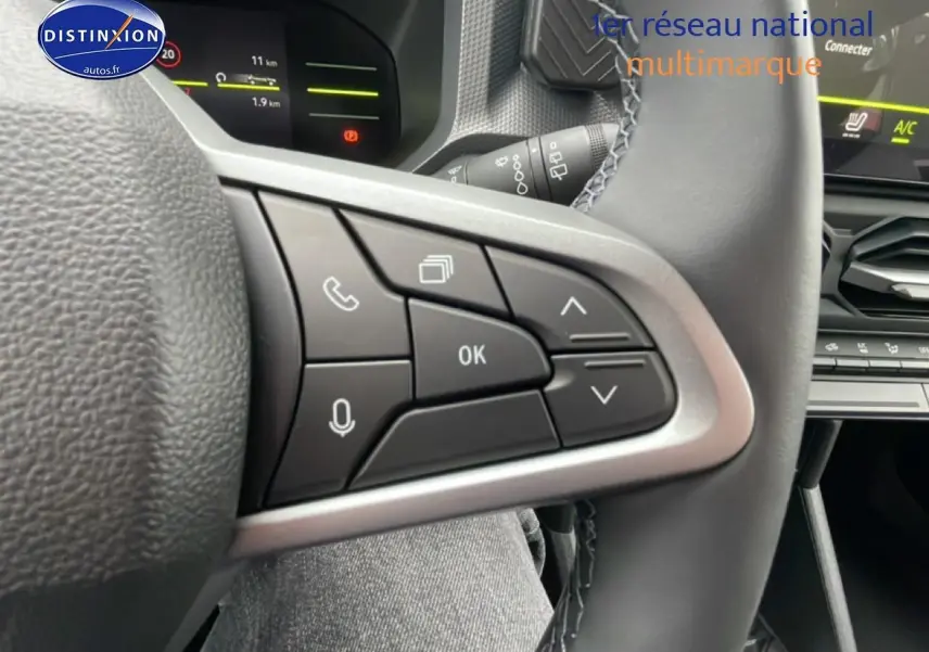 Gros plan sur les commandes multifonctions noires du volant du Dacia Duster 2026, intérieur gris et noir.