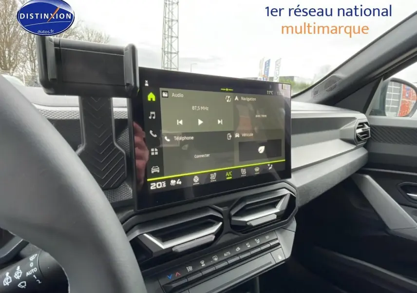 Vue intérieure du tableau de bord du Dacia Duster 2026 avec écran tactile central et commandes climatisation.