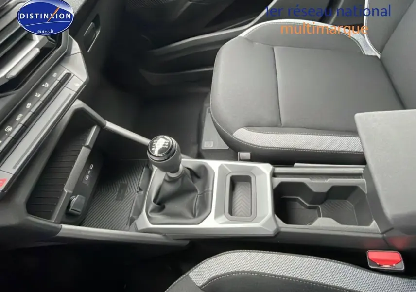 Vue intérieure centrée sur la console centrale et levier de vitesses manuelle du Dacia Duster 2026, sièges noirs.