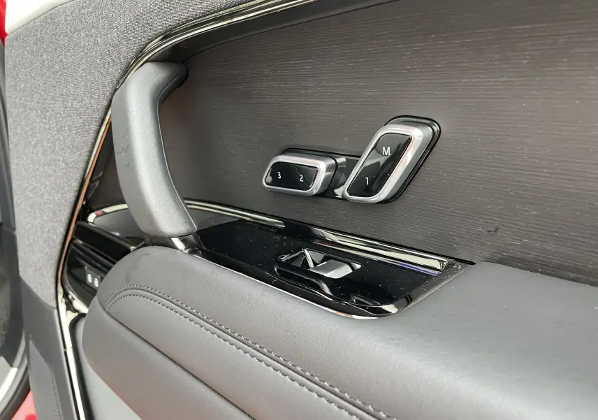 Détail de la commande de réglage mémoire des sièges sur la porte côté conducteur du Range Rover Sport P440 HSE R-Dynamic rouge.