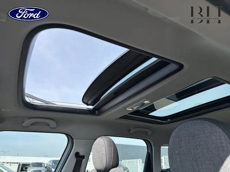 Toit panoramique ouvert vu de l'intérieur sur un MINI Countryman Moonwalk Grey avec ciel de pavillon anthracite.