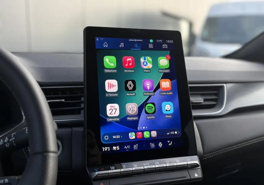 Vue intérieure centrée sur l'écran tactile vertical du système multimédia du Renault Symbioz 2025, volant partiellement visible.