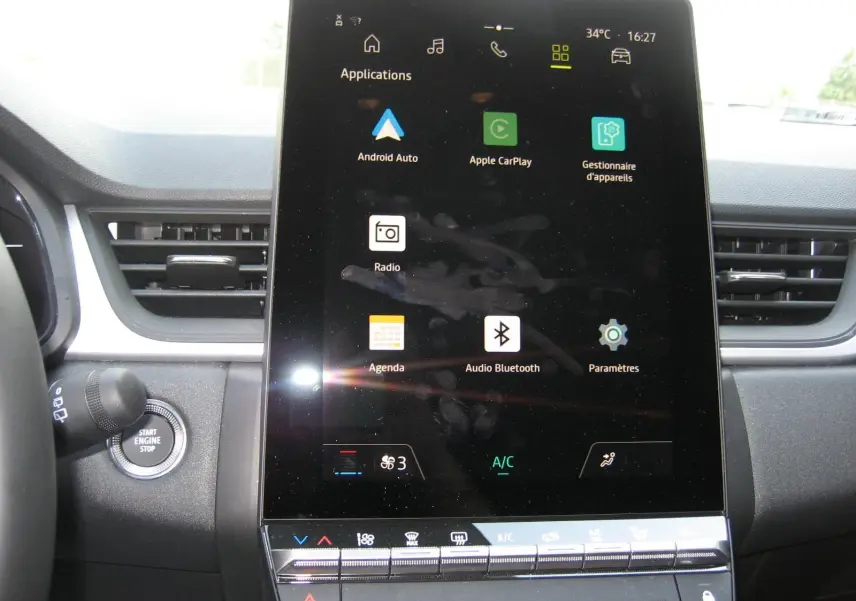 Vue intérieure centrée sur l'écran tactile vertical du tableau de bord du Renault Captur II bleu Iron, affichant les applications connectées.