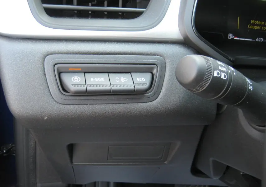 Gros plan sur les boutons de commande E-SAVE, ECO et éclairage à gauche du volant dans le Renault Captur II bleu Iron 2025.