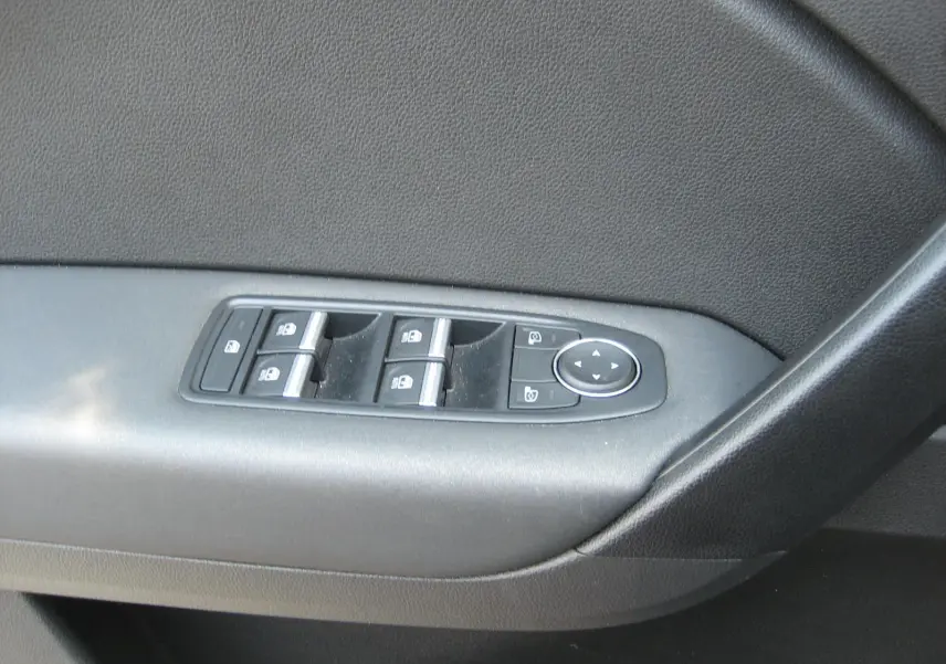 Panneau de commande des vitres électriques côté gauche intérieur d'une Renault Captur II bleu Iron, avec boutons de verrouillage et réglage des rétroviseurs.