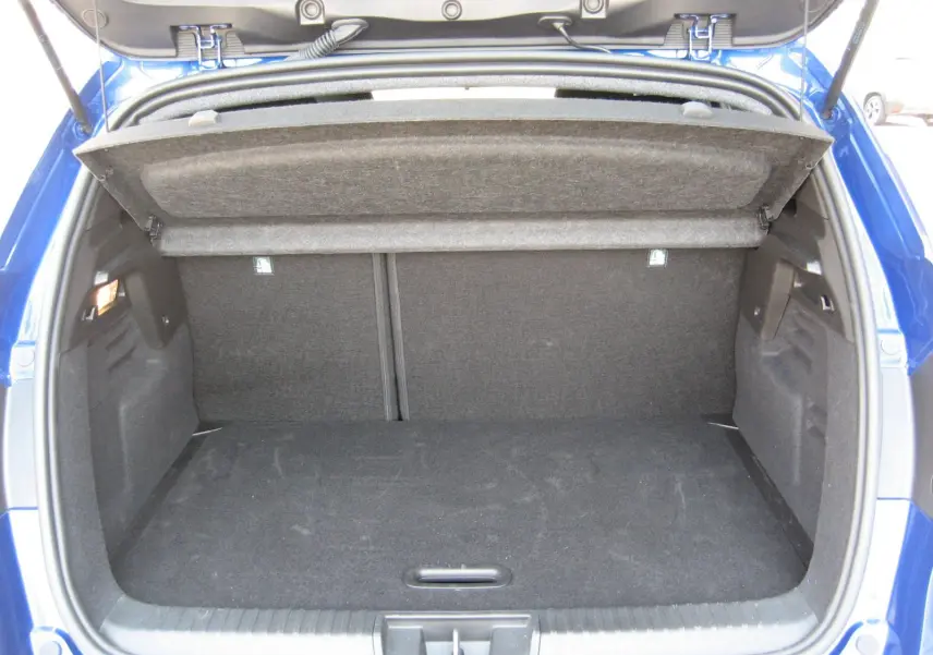 Coffre ouvert du Renault Captur II bleu iron, vue arrière montrant l’espace de rangement et la tablette cache-bagages relevée.
