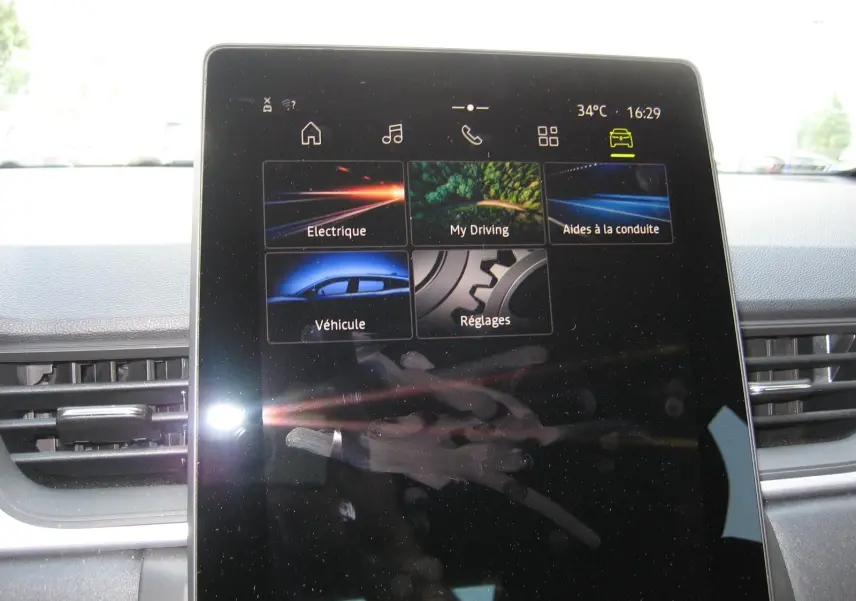 Écran tactile central du tableau de bord du Renault Captur II 1.6 E-TECH Hybride 2025 affichant les menus de conduite et réglages.