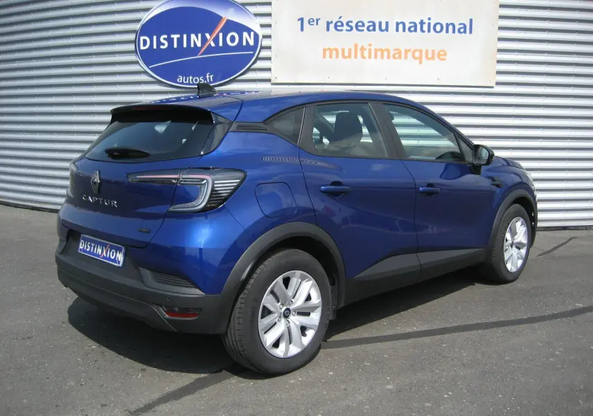 Renault Captur II 1.6 E-Tech hybride bleu Iron vu en 3/4 arrière droit, avec feux arrière LED et jantes alliage.