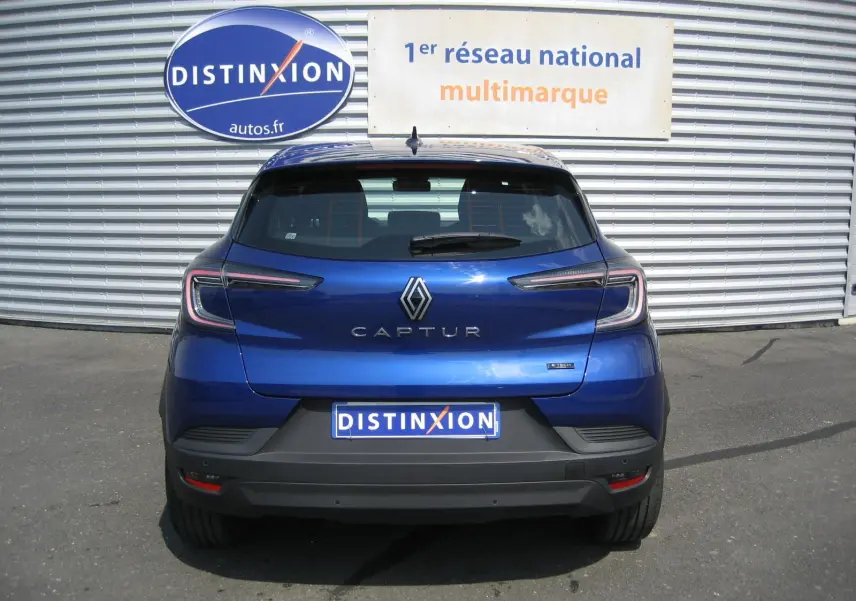 Vue arrière d'un Renault Captur II bleu iron 2025 avec feux LED et logo distinctif sur un parking extérieur.