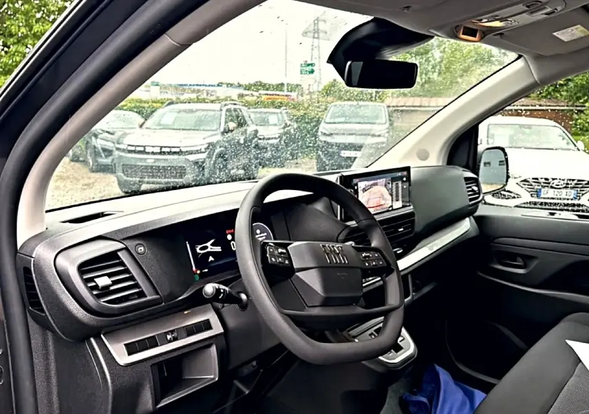 Vue intérieure côté conducteur du Fiat Scudo Combi gris titane, avec tableau de bord moderne et écran tactile central.