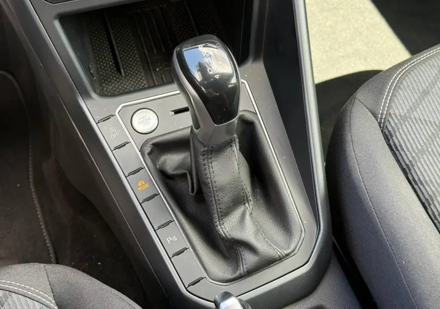 Gros plan sur le levier de vitesses automatique noir et argenté du Volkswagen Taigo gris, avec bouton Start/Stop visible.