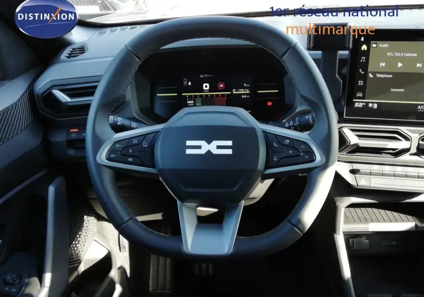 Vue intérieure centrée sur le volant multifonction du Dacia Duster 2026, avec tableau de bord numérique et écran tactile.