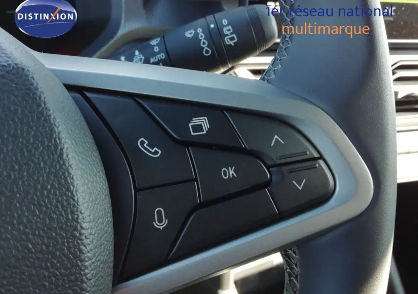 Gros plan sur les commandes multifonctions noires et grises du volant du Dacia Duster gris schiste métal, version 2026.