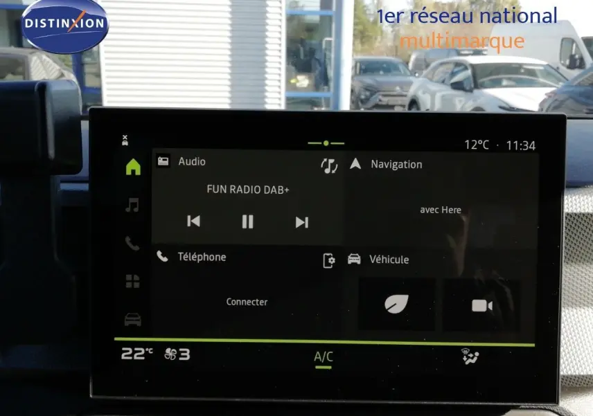 Écran tactile central du tableau de bord du Dacia Duster 2026, affichant radio, navigation et climatisation.