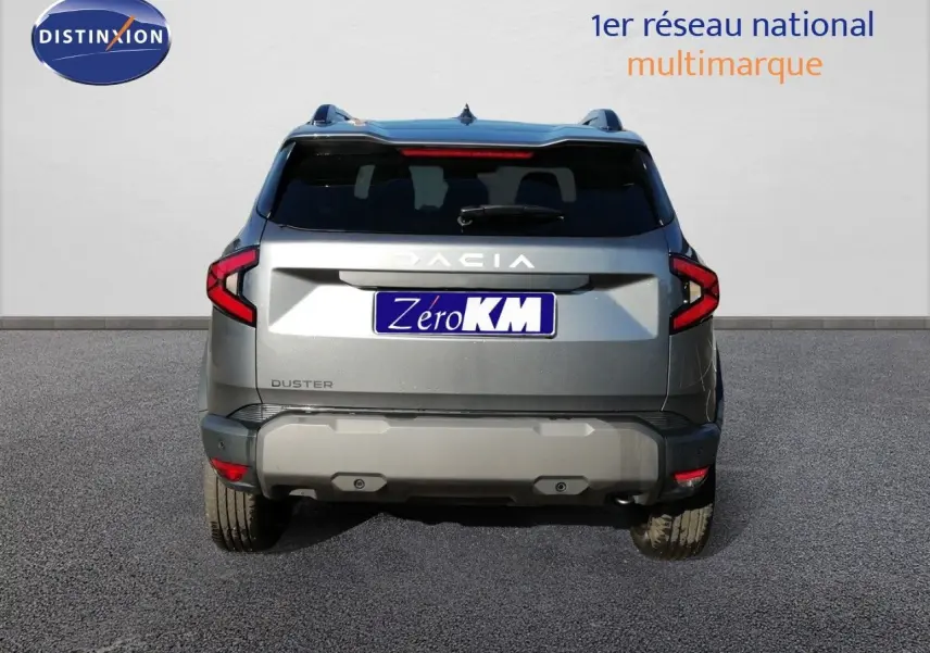 Vue arrière d'un Dacia Duster gris schiste métal 2026 avec feux LED et logo Dacia bien visible.