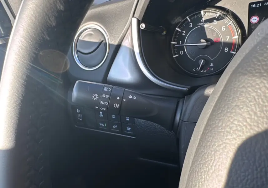 Gros plan sur le tableau de bord et le commodo gauche du Suzuki Vitara 2025 en intérieur, avec compte-tours visible.