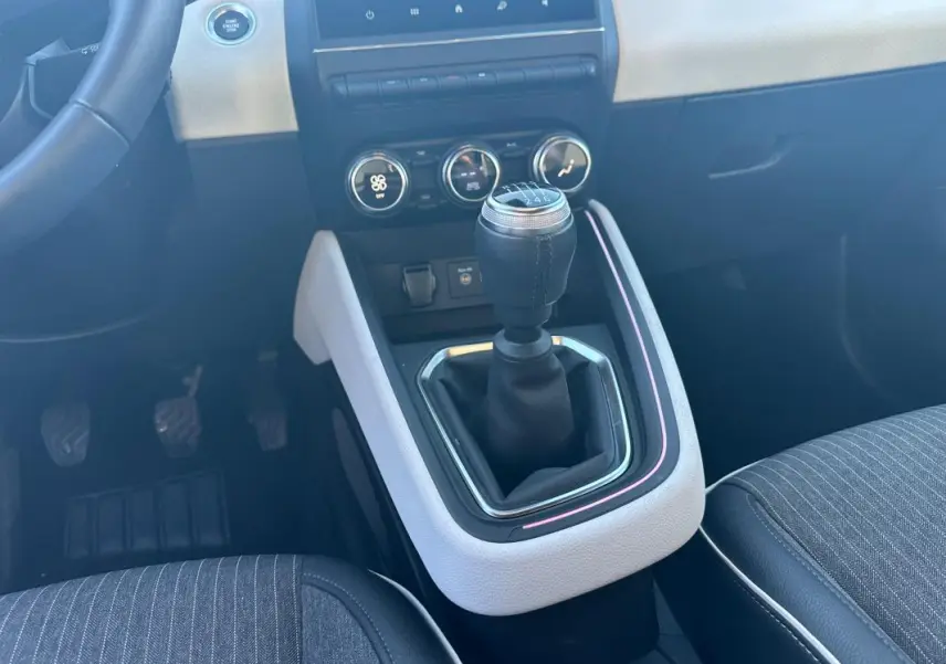 Le levier de vitesse manuel de la Renault Clio V TCe 90 Intens 2021, avec console centrale claire et sièges gris.