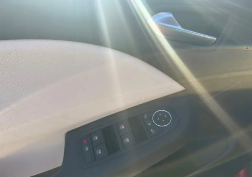 Panneau de porte intérieur beige et noir de Renault Clio 2021 Intens, avec commandes de vitres et rétroviseurs.