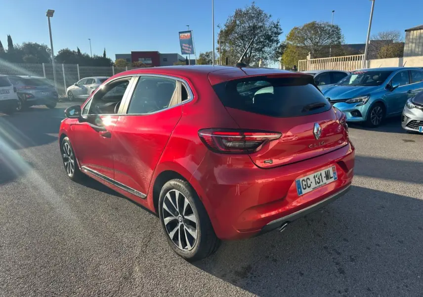 Renault Clio rouge foncé vue 3/4 arrière droit, jantes alliage 17 pouces et feux arrière LED visibles.