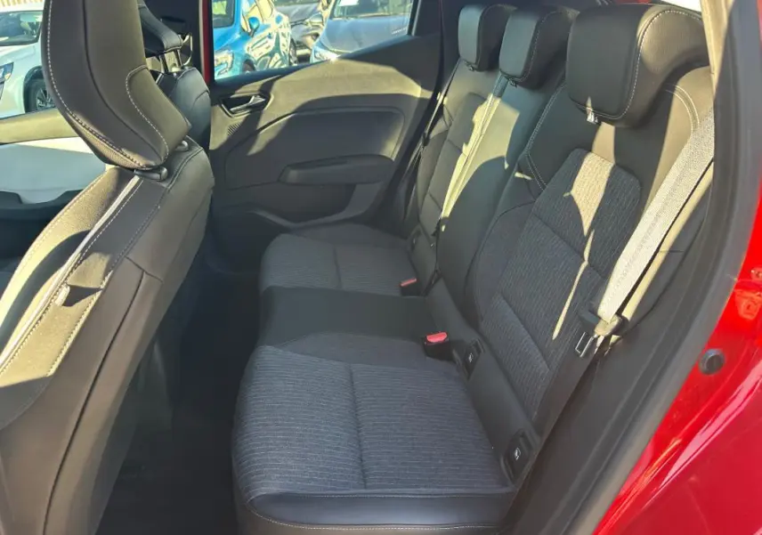 Vue intérieure côté droit des sièges arrière en tissu gris et cuir noir d'une Renault Clio rouge foncé 2021.