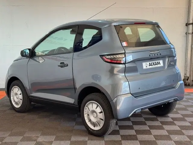Vue 3/4 arrière droite d'une Aixam Ambition 0.5 City Pack gris foncé avec rétroviseur caméra côté conducteur.