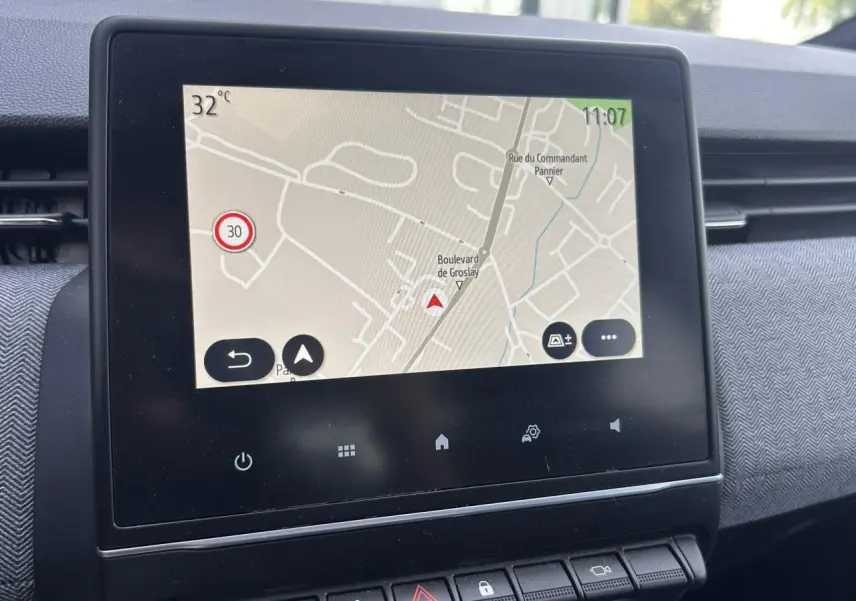 Écran tactile central affichant la navigation dans l’habitacle de la Renault Clio Gris Rafale, vue de face rapprochée.