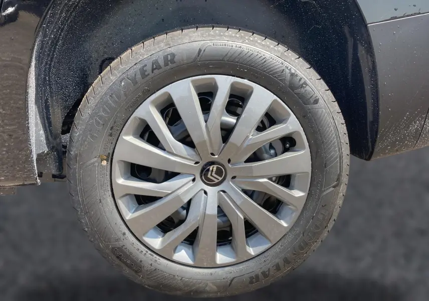 Gros plan sur la roue avant gauche noire d’un Citroën Berlingo 2026 avec jante alu et logo Citroën central.