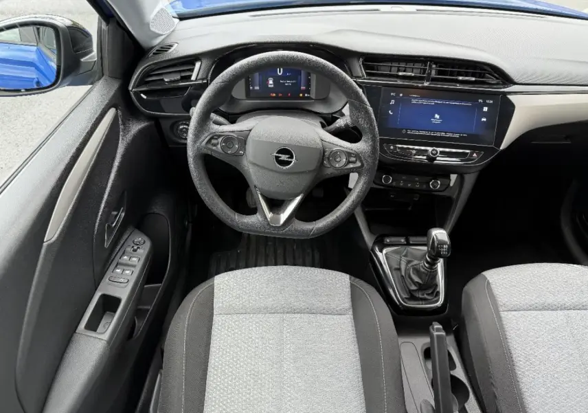 Vue intérieure frontale de l’Opel Corsa bleu voltaik 2025, mettant en valeur le volant, la boîte manuelle et l’écran tactile.