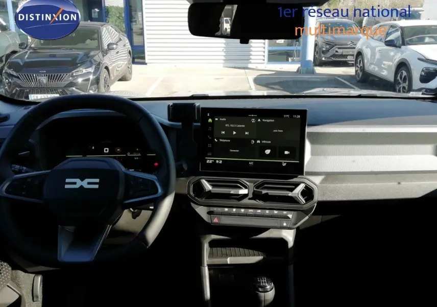 Vue intérieure du tableau de bord et volant du Dacia Duster 2026, avec écran tactile central et levier de vitesses manuel.