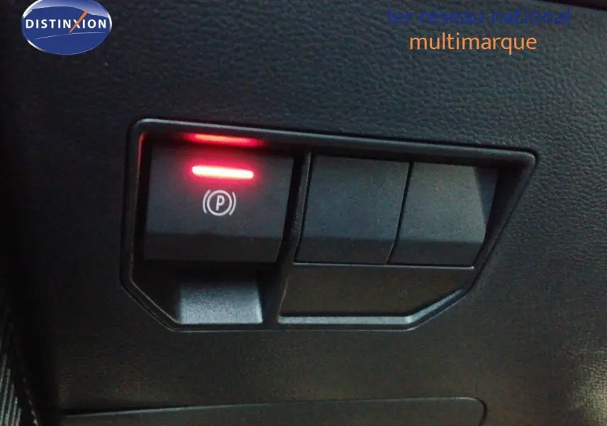 Gros plan sur le bouton de frein à main électrique allumé dans l’habitacle du Dacia Duster gris schiste métal 2026.
