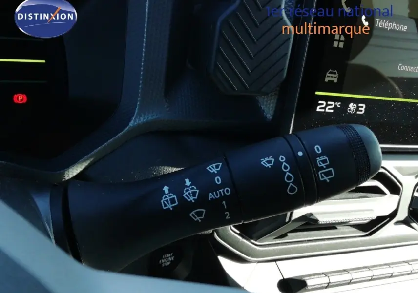 Gros plan sur la commande des essuie-glaces du Dacia Duster gris schiste métal, avec tableau de bord et écran tactile en arrière-plan.