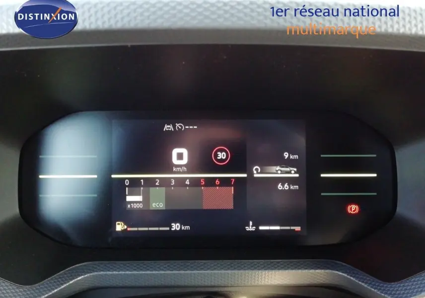 Vue rapprochée du tableau de bord numérique du Dacia Duster gris schiste, affichant vitesse, régime et autonomie.