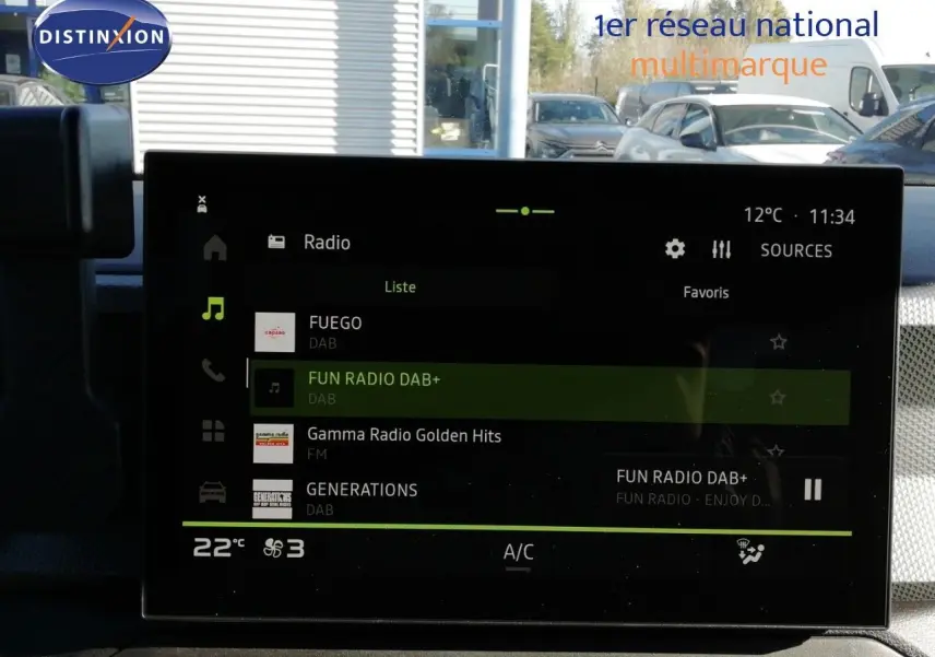 Écran tactile central du Dacia Duster 2026 affichant les stations radio, avec tableau de bord gris et ambiance intérieure moderne.