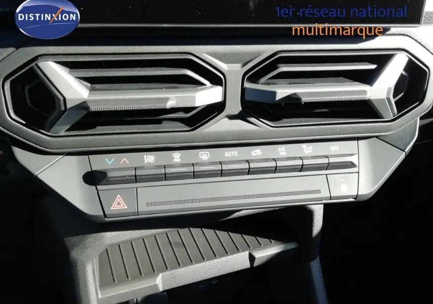 Détail de la console centrale avec les aérateurs hexagonaux et les commandes de climatisation du Dacia Duster gris schiste.